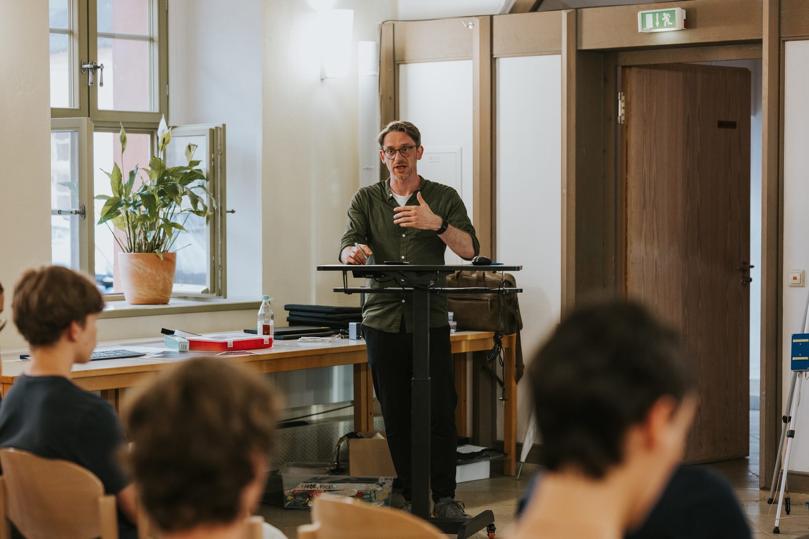 Rene Seidel spricht bei einem Workshop zu einer Gruppe von Teilnehmenden.
